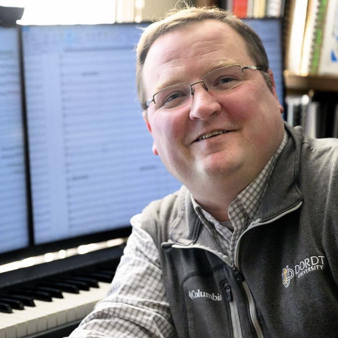 Dr. Rose at the piano with scores